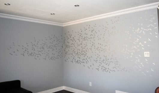 Stenciling an accent wall in a living room using the Flock of Cranes birds wall pattern in metallic silver over gray. Cutting Edge Stencils http://www.cuttingedgestencils.com/bird-flock-wall-stencil-pattern.html