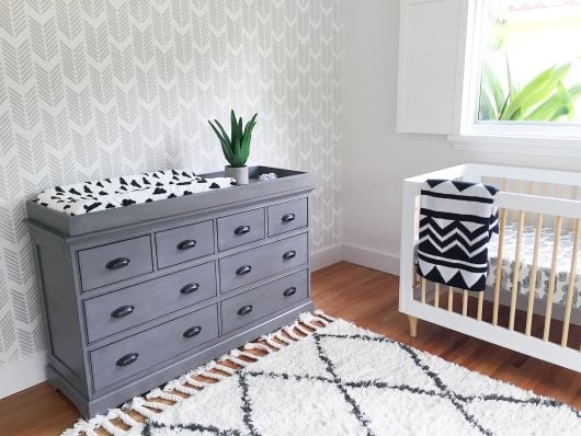 A DIY gray, white, black stenciled accent wall in a nursery using the Drifting Arrows wall pattern from Cutting Edge Stencils. http://www.cuttingedgestencils.com/drifting-arrows-stencil-pattern-diy-decor.html