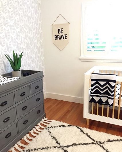A DIY gray, white, black stenciled accent wall in a nursery using the Drifting Arrows wall pattern from Cutting Edge Stencils. http://www.cuttingedgestencils.com/drifting-arrows-stencil-pattern-diy-decor.html