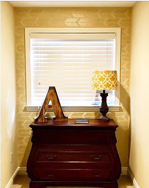 A DIY golden yellow stenciled accent wall using the Drifting Arrows Allover pattern from Cutting Edge Stencils. http://www.cuttingedgestencils.com/drifting-arrows-stencil-pattern-diy-decor.html