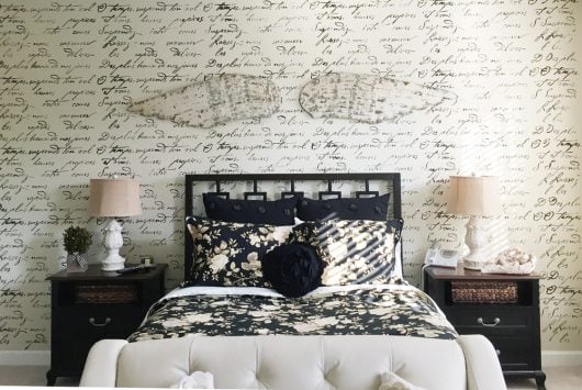 A black and white DIY stenciled bedroom accent wall using the French Poem Allover Stencil from Cutting Edge Stencils. http://www.cuttingedgestencils.com/french-typography-letter-wall-stencil.html
