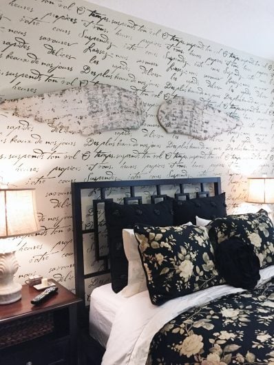 A black and white DIY stenciled bedroom accent wall using the French Poem Allover Stencil from Cutting Edge Stencils. http://www.cuttingedgestencils.com/french-typography-letter-wall-stencil.html