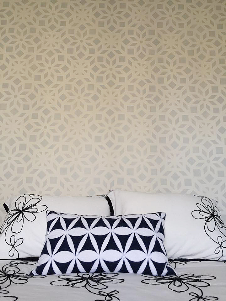A gray and white stenciled bedroom accent wall using the Kerala Allover Stencil, an Indian inspired wallpaper pattern, from Cutting Edge Stencils. http://www.cuttingedgestencils.com/kerala-indian-stencil-geometric-pattern-stencils.html