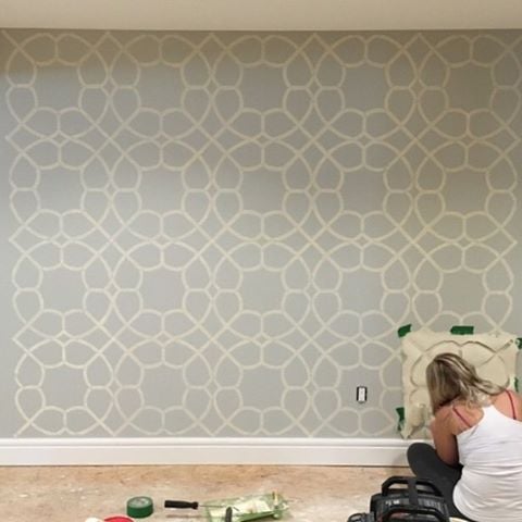 Stenciling an accent wall on HGTV's Leave It To Bryan basement makeover using the Coco Trellis allover Stencil from Cutting Edge Stencils. http://www.cuttingedgestencils.com/coco-trellis-allover-pattern-stencil.html