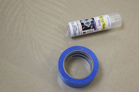 Adhesive spray and blue painters tape for stencil