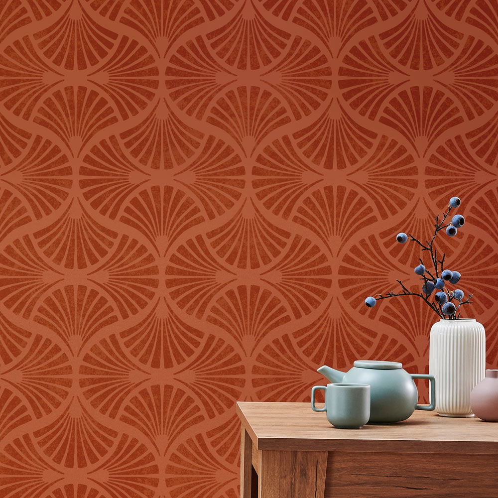 Decorative stenciled wall with geometric pattern and a wooden table with teapots and a vase.