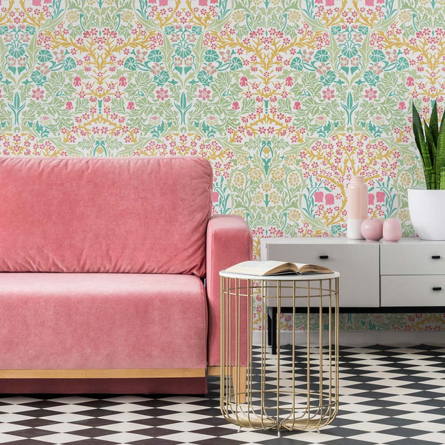 Pink sofa in a room with floral wall stencil and a checkered floor.