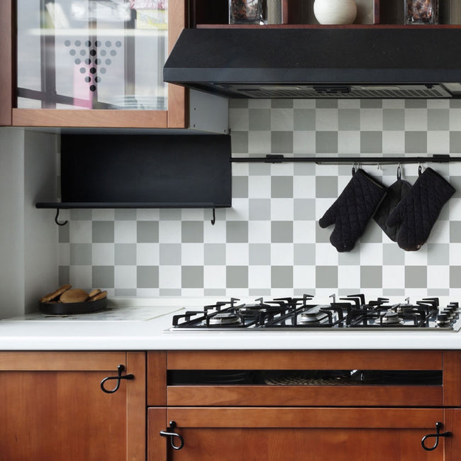 Modern kitchen with wooden cabinets, checkered backsplash, and black stove.