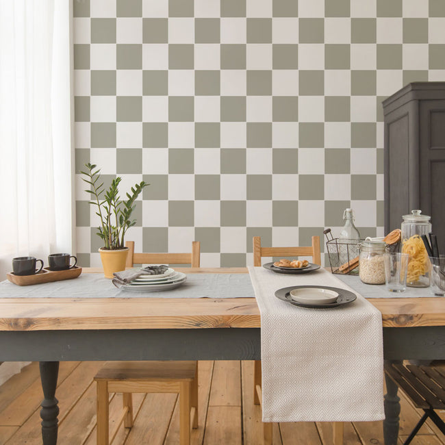Dining room with a checkered wall stencil pattern, wooden table, and chairs.