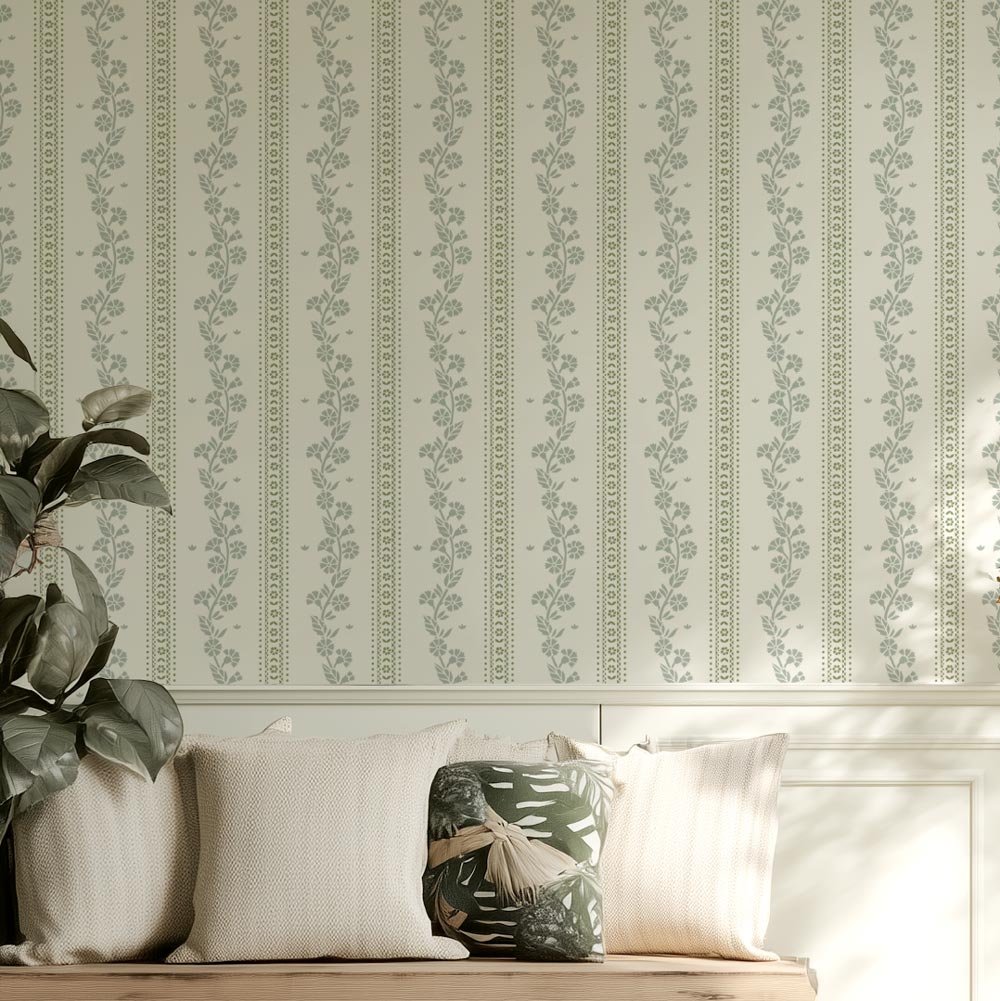 Decorative cottage style floral stripe wall stencil, plant, and pillows on a bench.