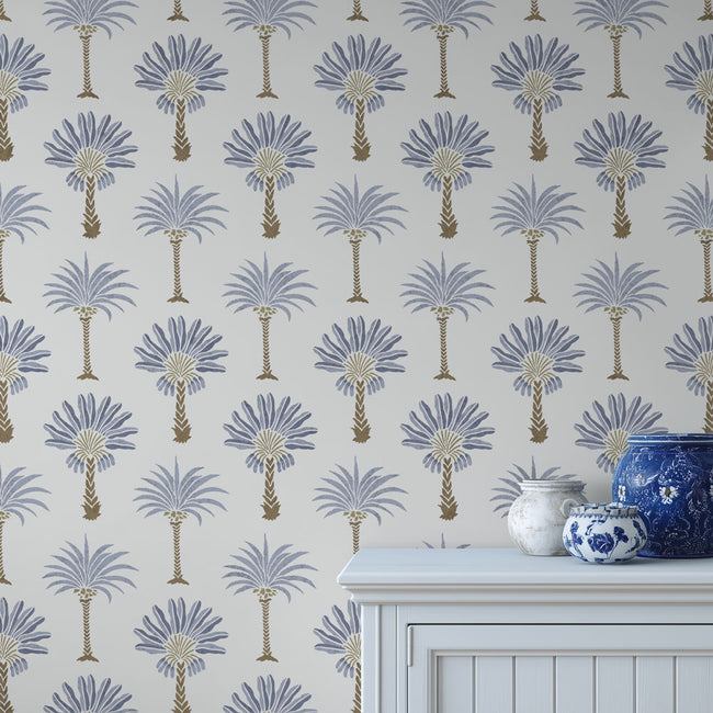 Stenciled palm tree pattern on a light blue background, with decorative vases in the foreground.