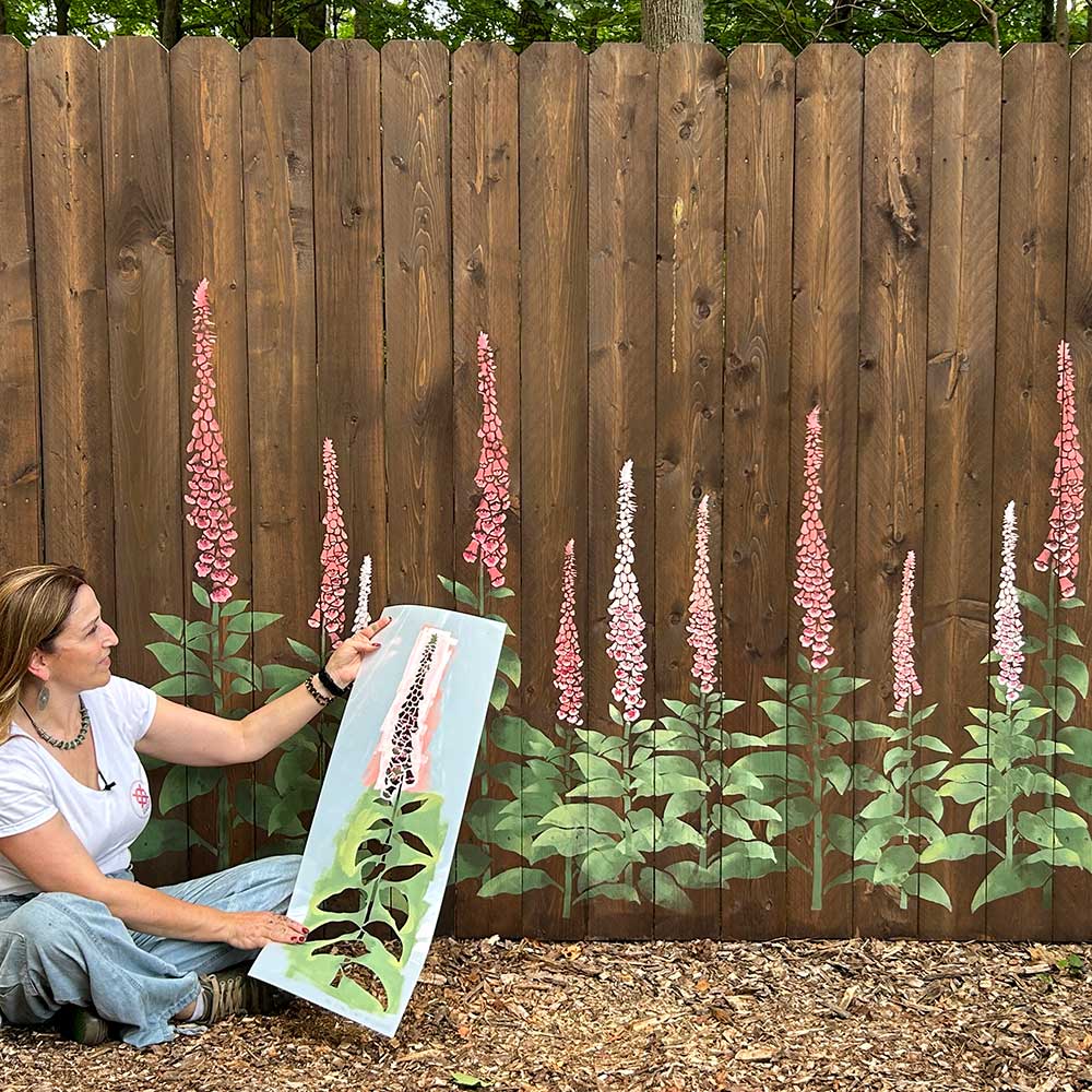Janna stenciled a floral mural on a wooden fence with foxglove stencil