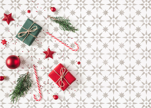 Christmas-themed decor with presents, ornaments, and candy canes on a stenciled background