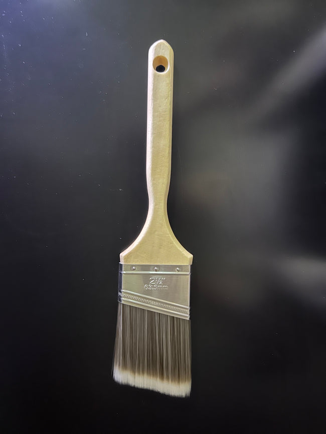 A single paint brush with a light wood handle and metal ferrule, shown upright against a dark black background.