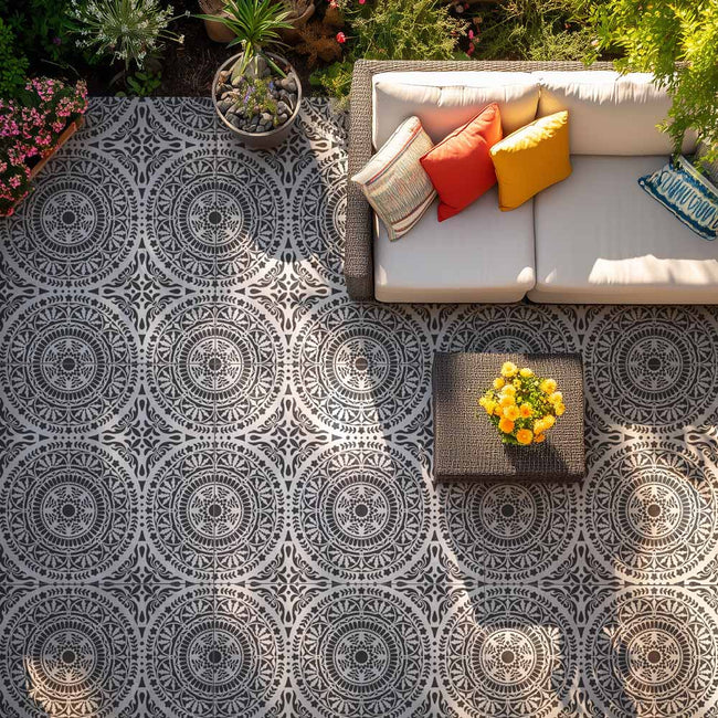 Outdoor seating area with a stenciled patterned floor and colorful pillows.