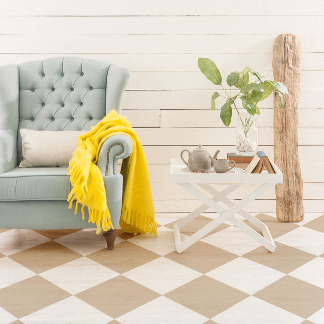 Living room with a gray sofa, yellow blanket, and a small white table with decor items.