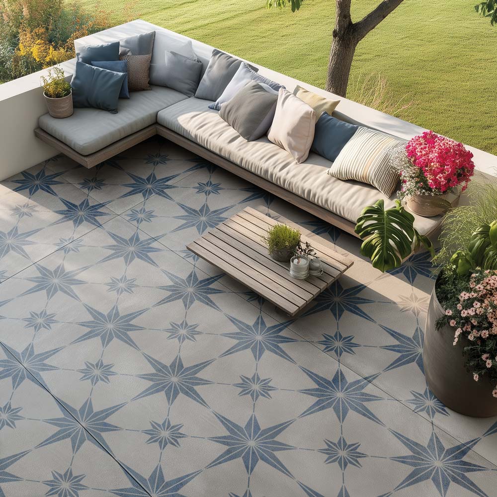 Outdoor stenciled patio with a sectional sofa, coffee table, and decorative elements on a patterned stencil tile floor.