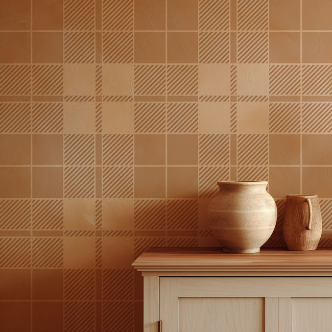 Two ceramic pots on a wooden surface against a tartan patterned brown stenciled wall.