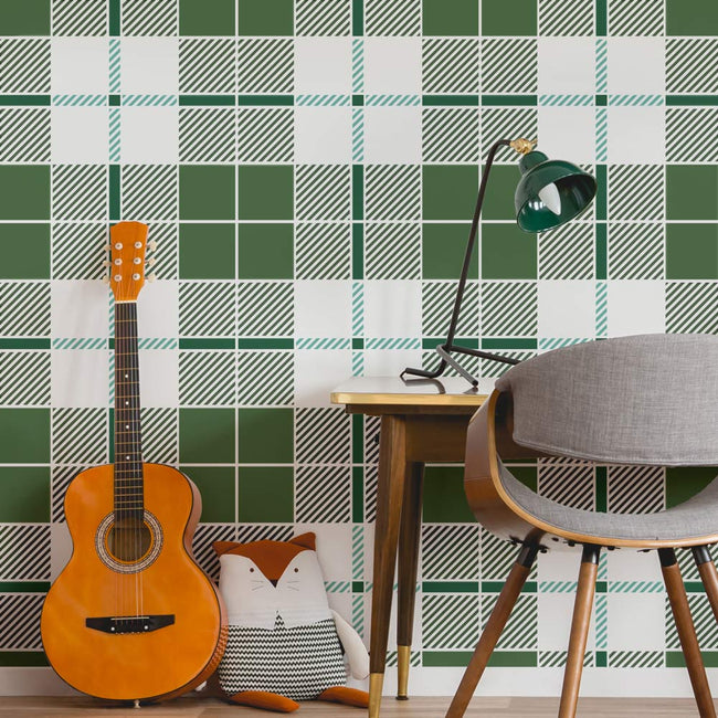 Guitar against a green and white tartan checkered stenciled wall with a chair and table.