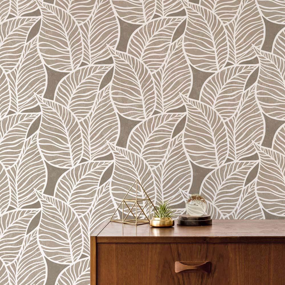 stenciled leaf pattern in neutral tones on a wall behind a wooden cabinet.