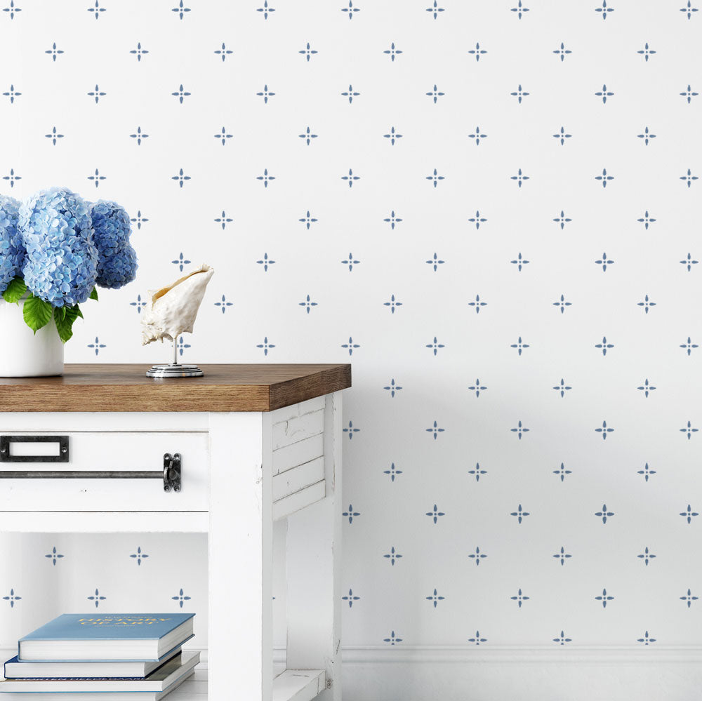 White cabinet with wooden top against a white wall with blue star stencil pattern