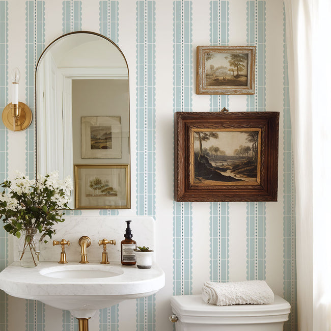 Bathroom with striped wall stencil, sink, mirror, and framed pictures.