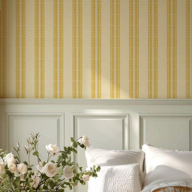 Bedroom with white headboard, yellow striped wall stencil, and floral arrangement.