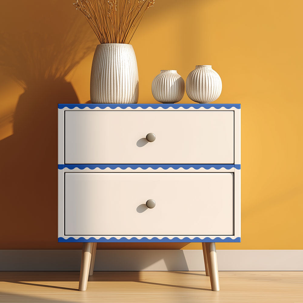 Two-drawer cabinet with decorative trim against a yellow wall