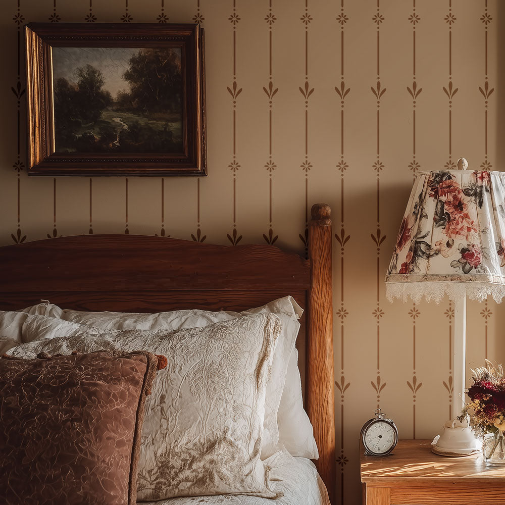 Bedroom with wooden headboard, floral lampshade, and decorative pillows against a patterned wall stencil
