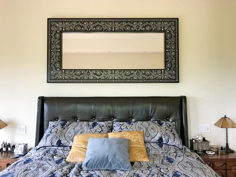 mirror hanging above bed