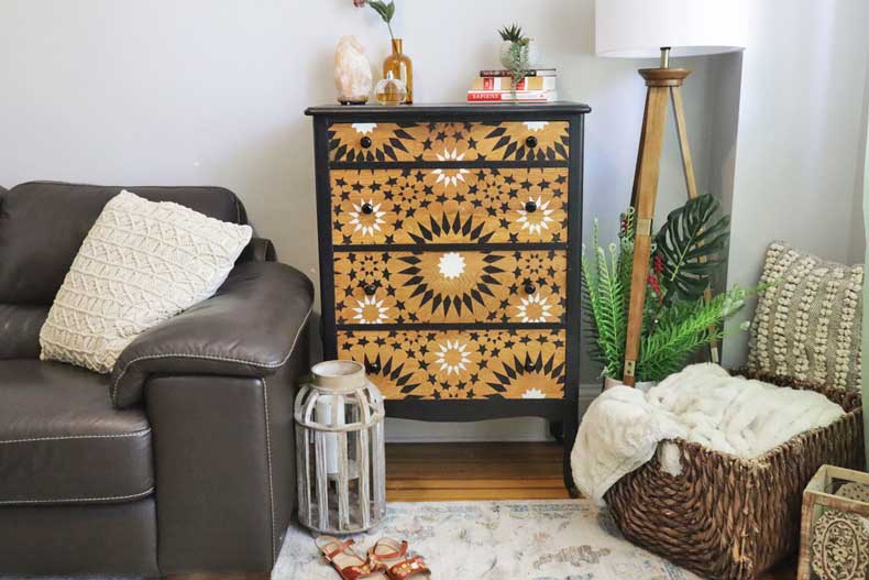 painted wood dresser with Moroccan tile stencil pattern against wall in room 