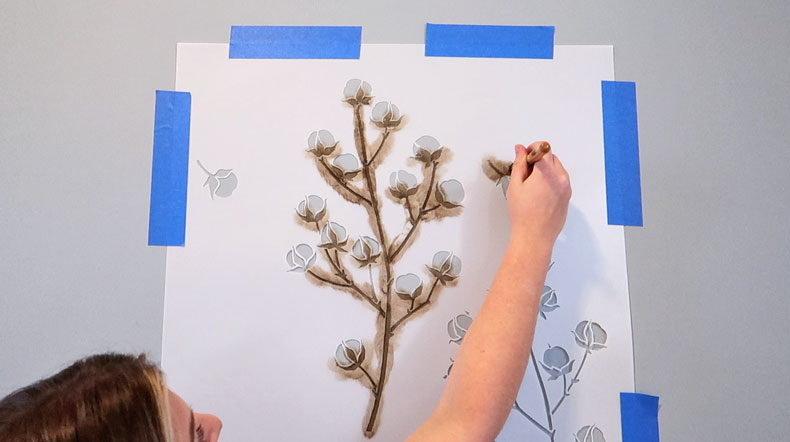 girl adding brown paint to cotton stencil