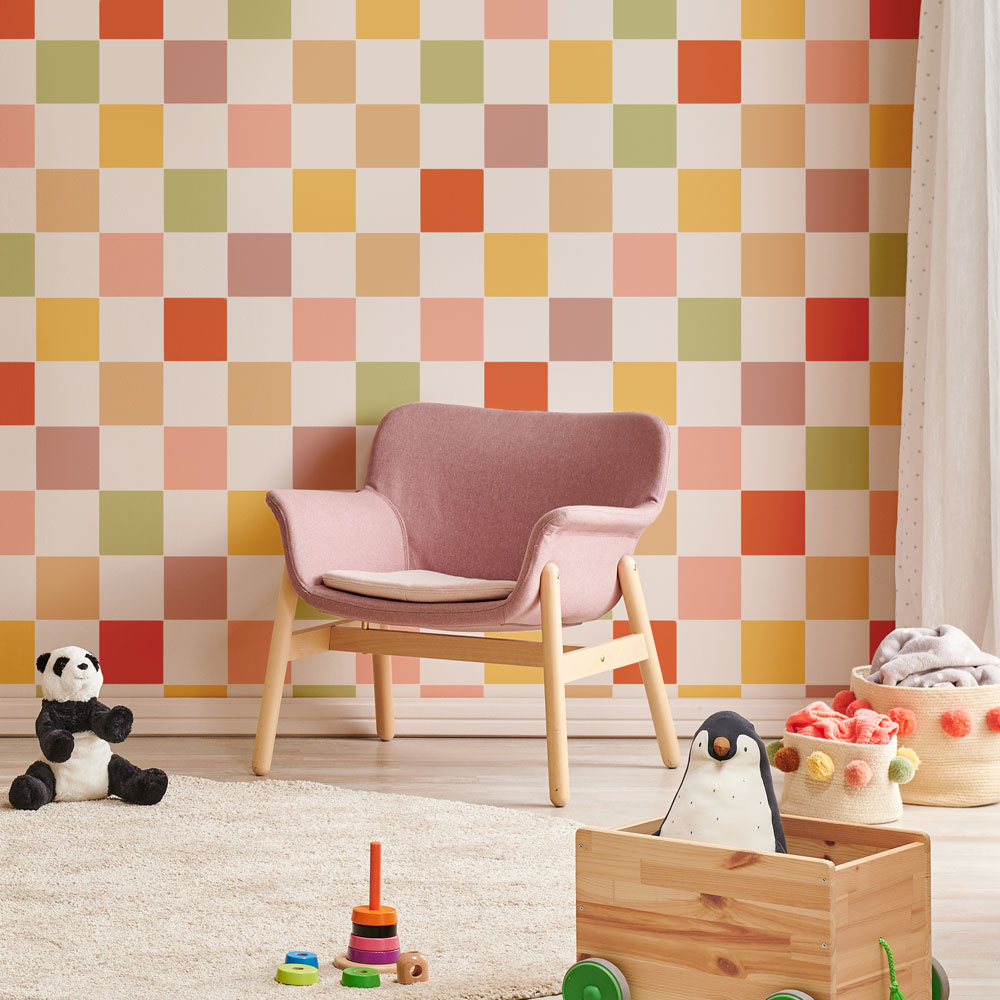Children's room with a pink chair, colorful checkered wall, and toys on the floor.