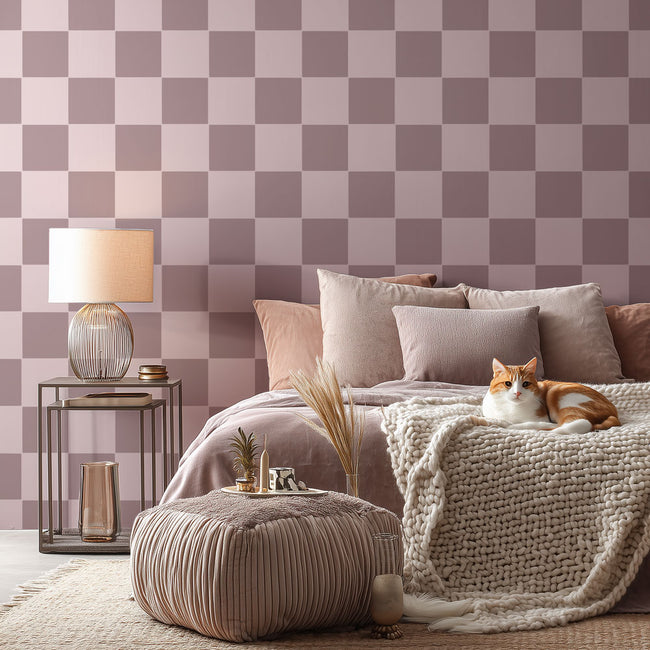 Cozy bedroom with checkered stenciled wallpaper, cat on bed, and decorative items.