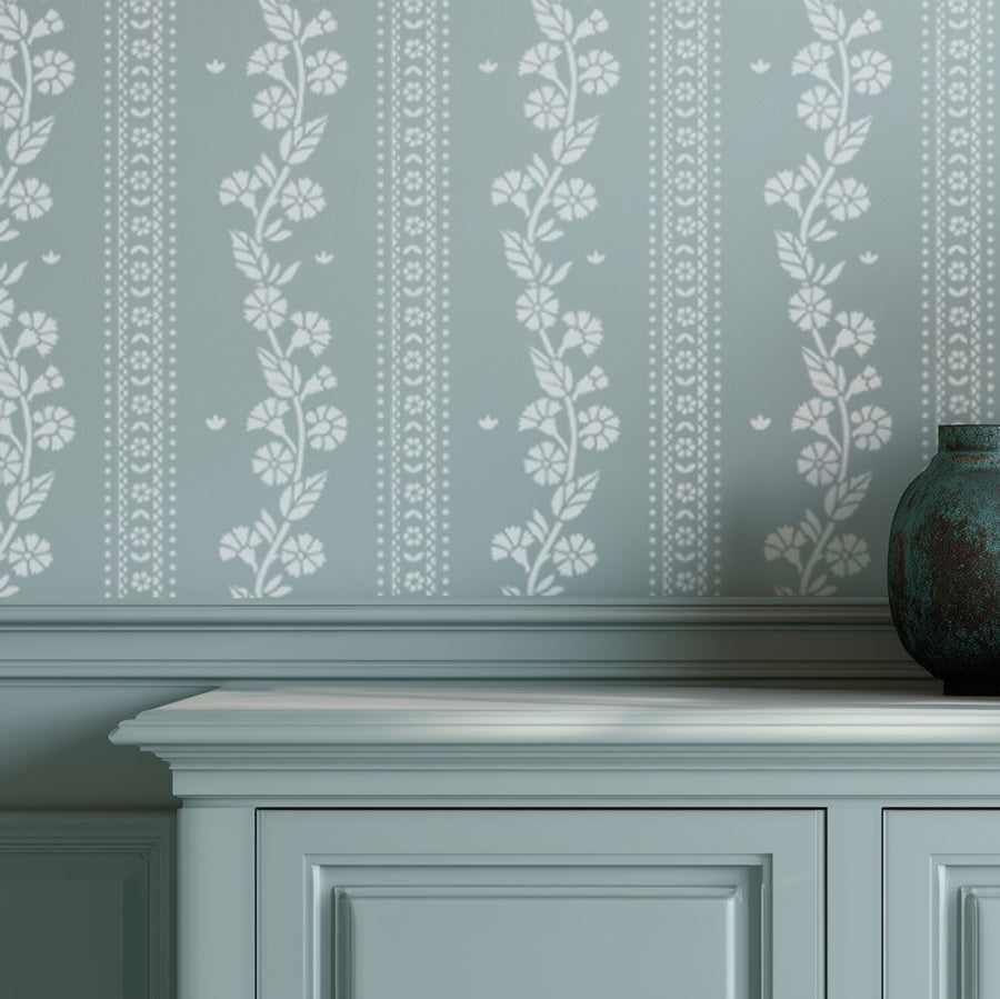 Decorative wall stencil with cottage inspired floral patterns on a light blue wall.