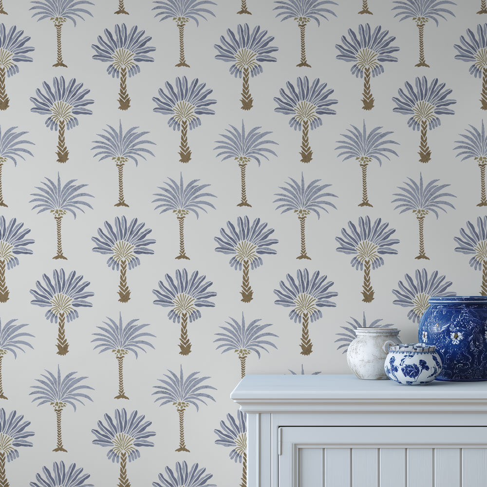 Stenciled palm tree pattern on a light blue background, with decorative vases in the foreground.