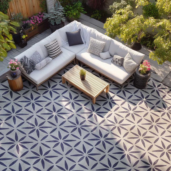 Outdoor patio with a sectional sofa, coffee table, and decorative elements on a patterned patio floor.