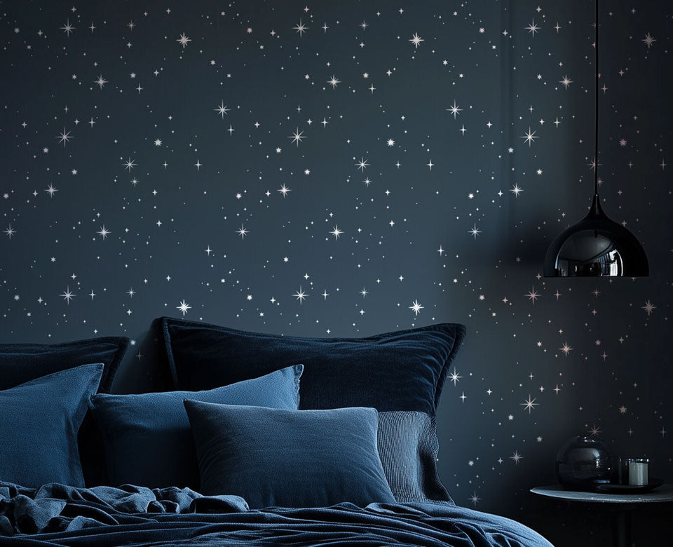 Bedroom with starry night wall design and blue bedding.