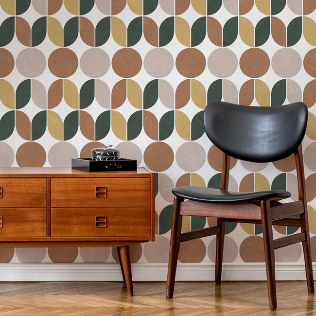 Wooden dresser and black chair against a patterned stencil wall.