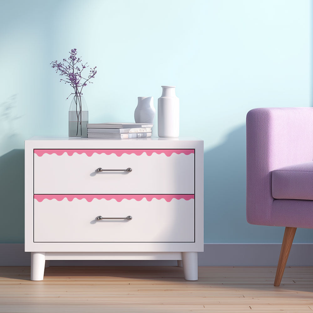 White nightstand with pink trim next to a pink chair against a light blue wall.