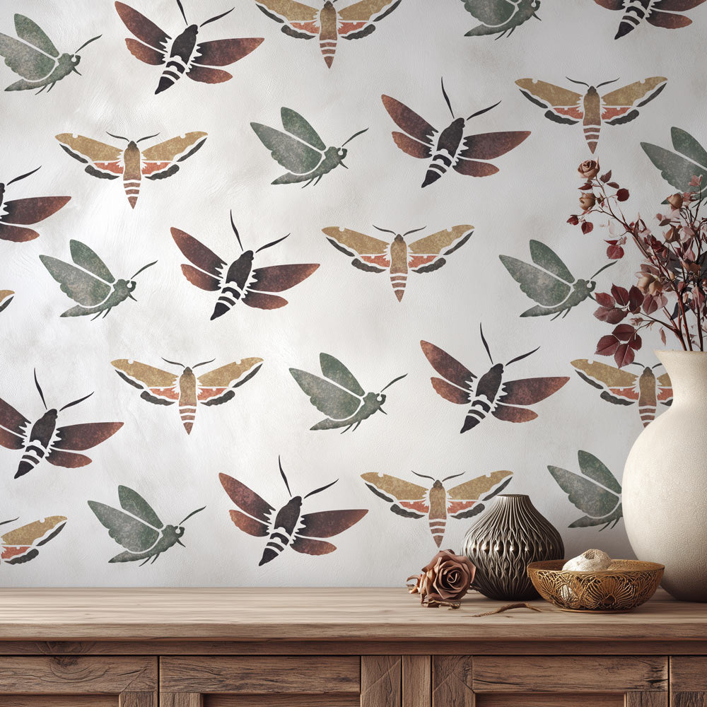 Wall stencil with moth pattern on a wall with decorative bowls and vases