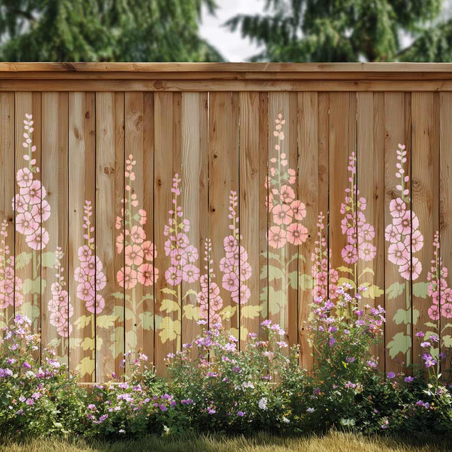 A wooden fence panel with a painted floral design featuring pink and peach flowers with green leaves, set in a garden with grass and trees in the background.