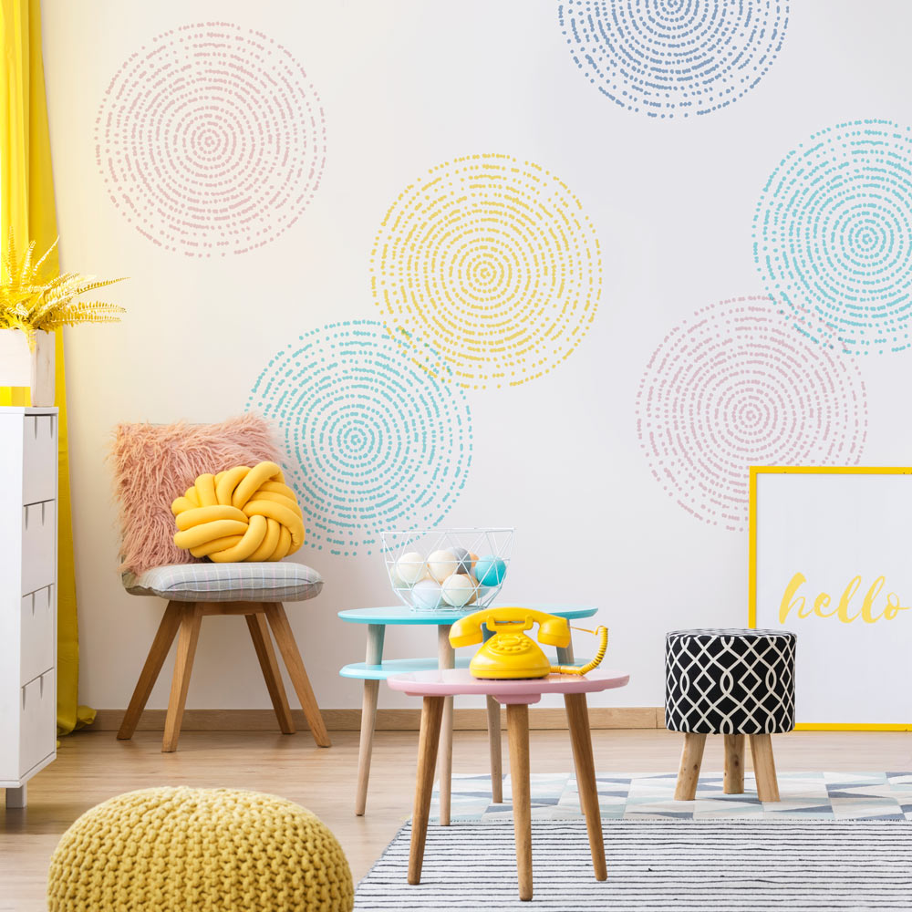 Children's room with colorful furniture and decorative stencil elements on a wall.