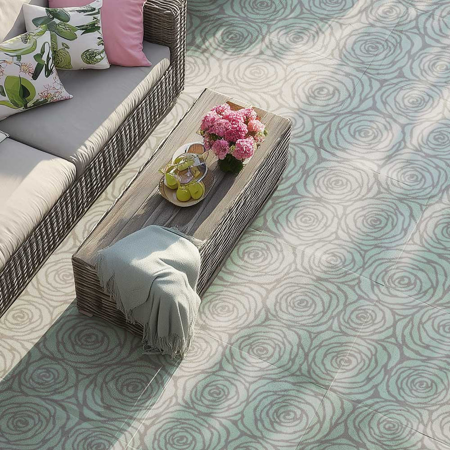 Outdoor seating area with a wooden table, cushions, and a floral arrangement on a stenciled patterned patio with large rose stencil.