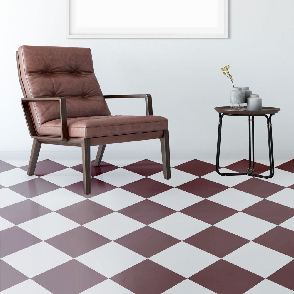 Brown leather armchair and small table on a checkered floor with white walls