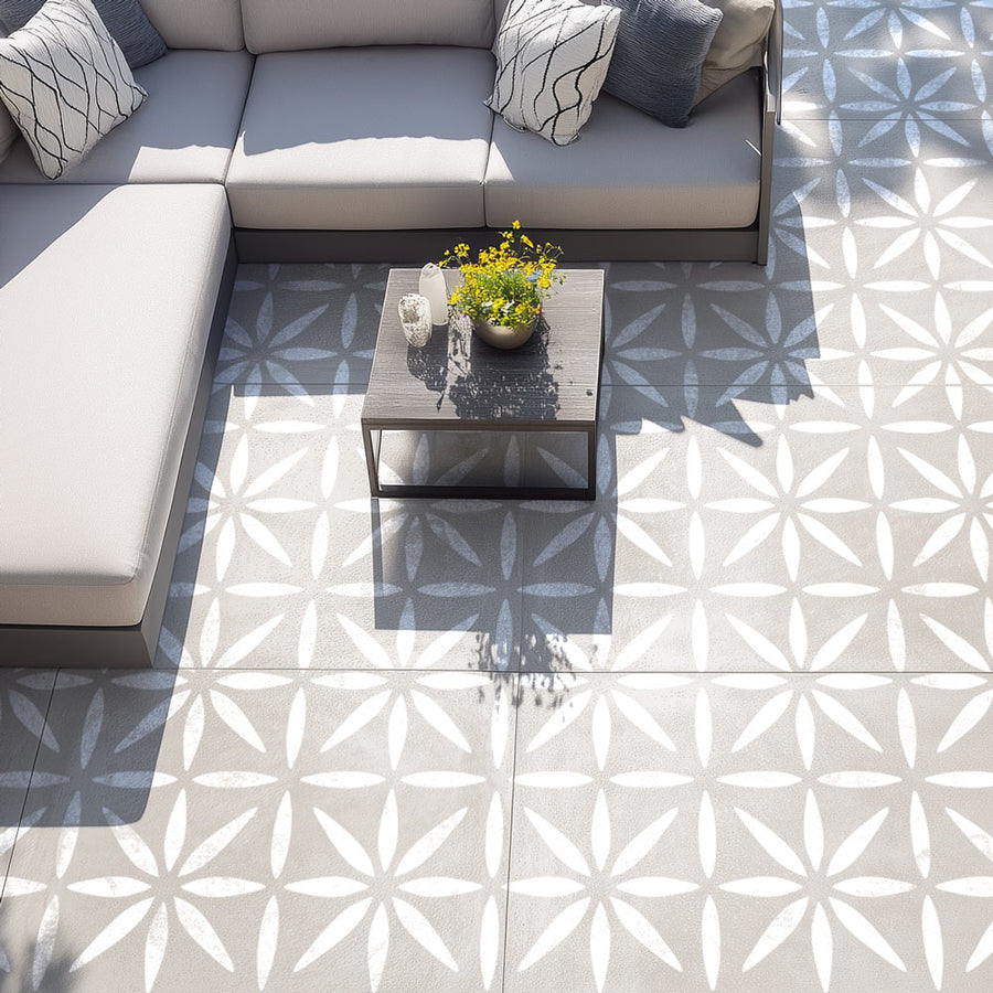 Outdoor patio with a sectional sofa, coffee table, and decorative elements on a patterned floor.