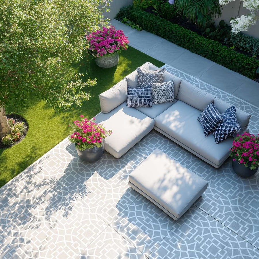 Stenciled floor on Outdoor concrete patio with a sectional sofa, cushions, and potted flowers