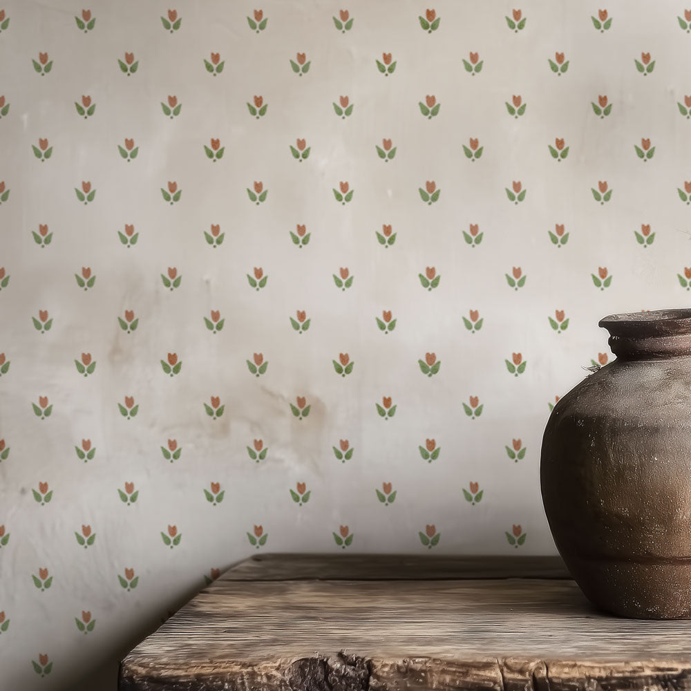 Decorative wall stencil with small floral pattern and a rustic vase on a wooden surface.