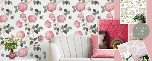 Floral wall stencil with pink flowers on a white wall, featuring a sofa and decorative items.
