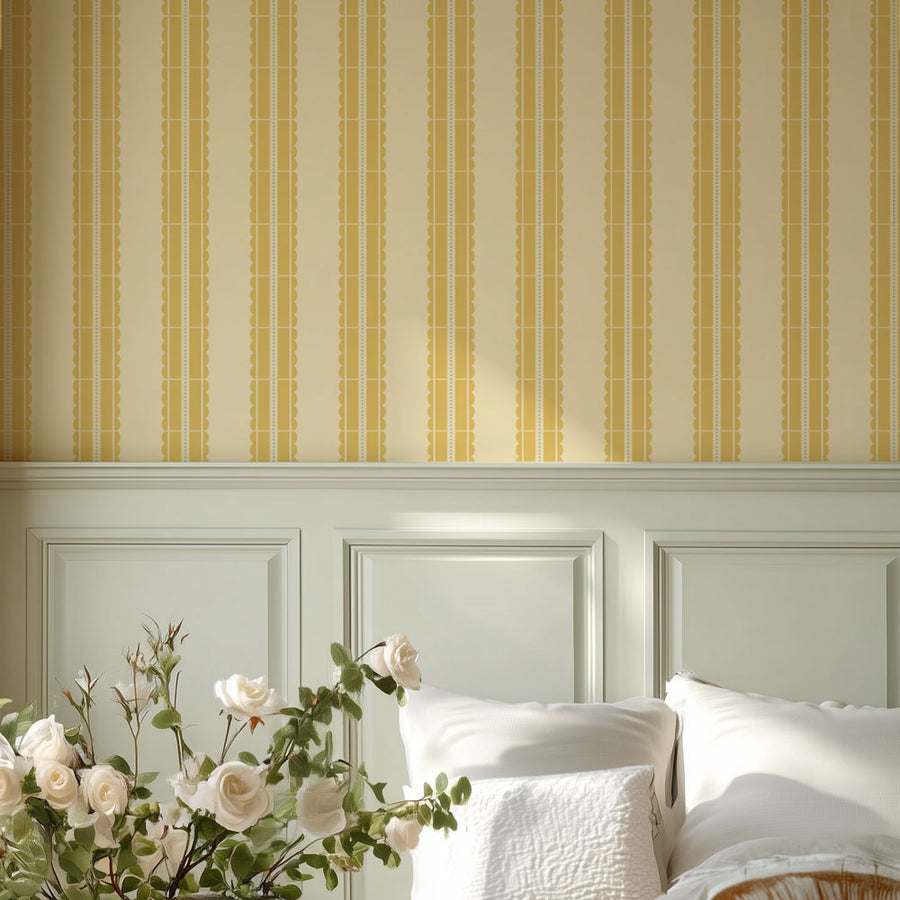 Bedroom with white headboard, yellow striped wall stencil, and floral arrangement.